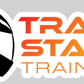 A die-cut sticker featuring a black racing helmet graphic on the left and the words 'TRACK START TRAINING' in bold orange-to-yellow gradient lettering on a white background, shown on a light gray backdrop.
