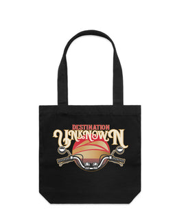 Black tote bag with design of the words destination unknown in front of a sunset, with motorbike handlebars on black tall tote bag
