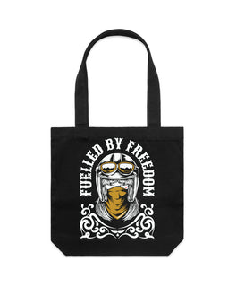 A black canvas tote bag with a graphic print of a helmeted motorcycle rider wearing a bandana, with the text 'FUELLED BY FREEDOM' in white.