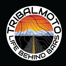 Design of a sunset with road and mountains, layered with topography lines and surrounded by the words TribalMoto Life behind bars on a decal