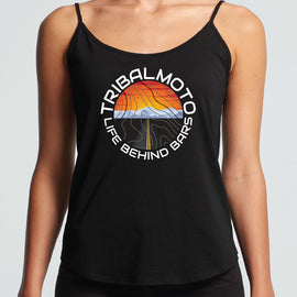 circle design includes the words TribalMoto and Life Behind Bars with a sunset, mountains and a road. Layered with topographical lines on black tank